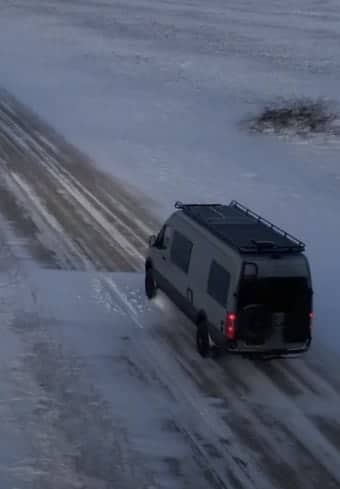 Medisinsk bil parkert på en snødekket vei i ødemarken